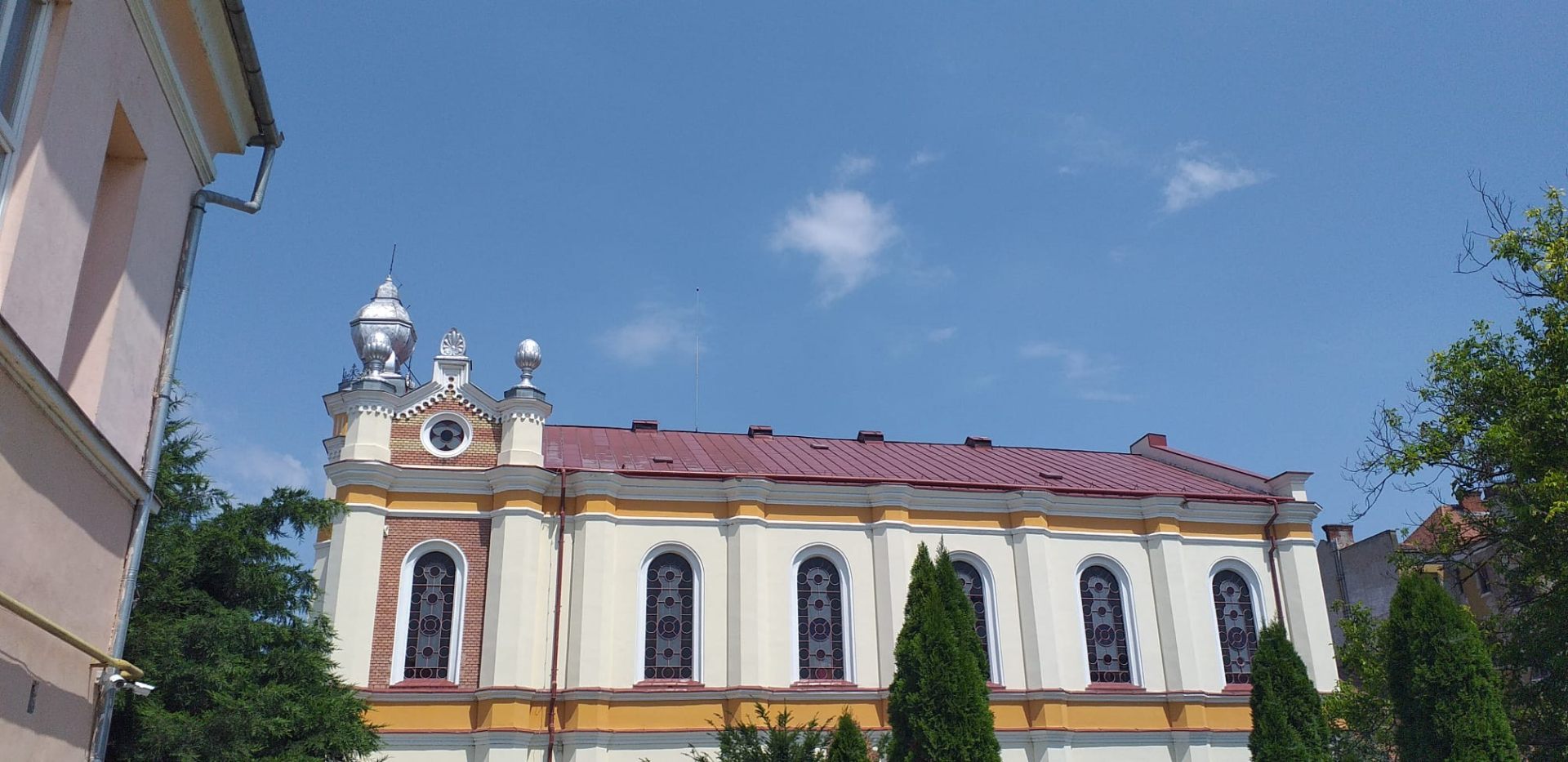 Acoperiș tablă vopsit roșu pe biserică restaurată